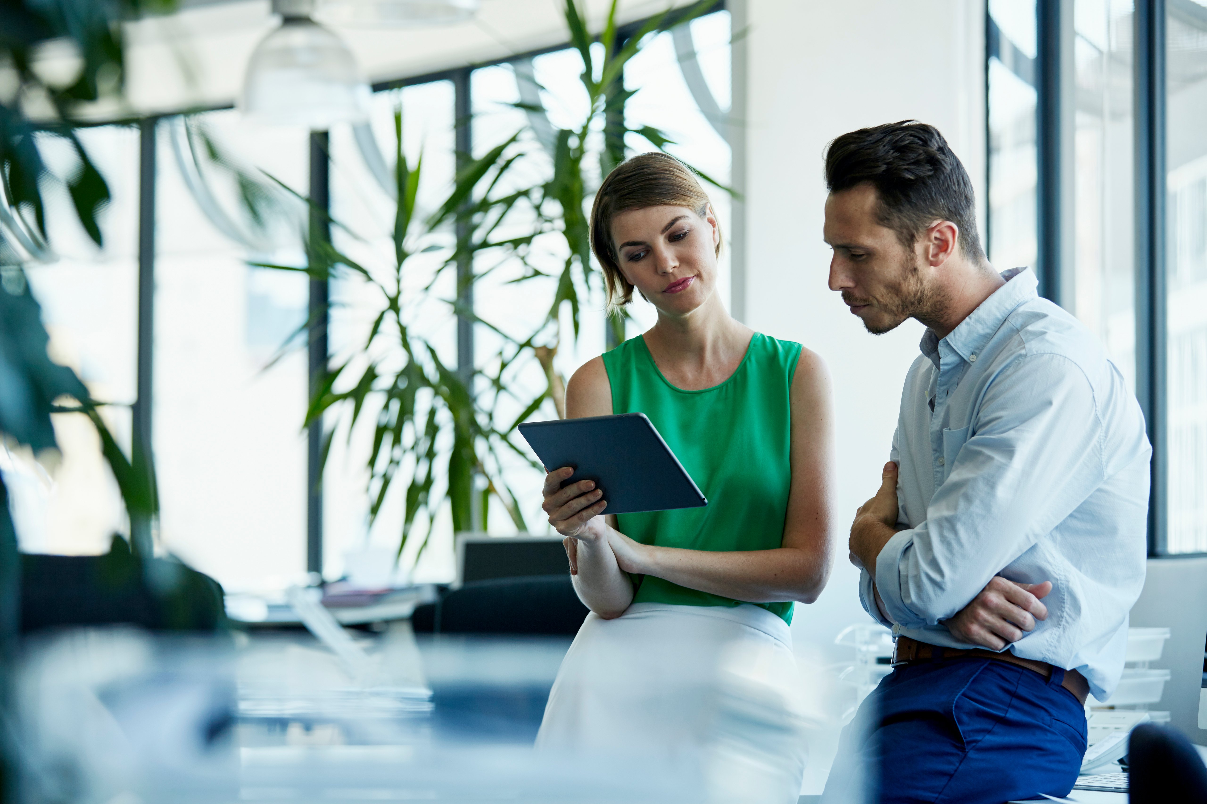 Woman and man in discussion, looking at iPad